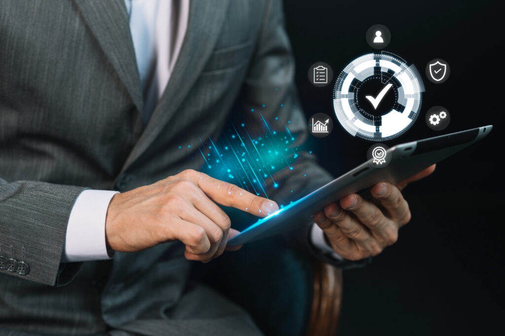 A businessman using a tablet with futuristic digital analytics and technology icons overlaying the screen.