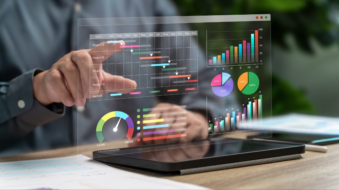 Person interacting with a holographic display showing project timelines, bar charts, pie charts, and gauges, analyzing data on a tablet.