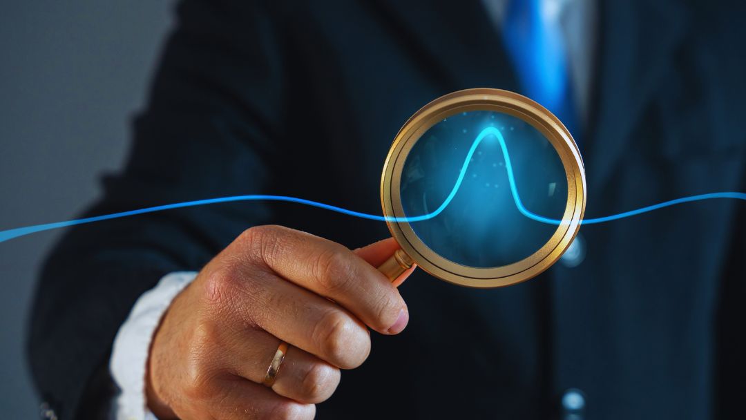 Businessman in suit holding magnifying glass showing neon blue demand curve graph. Represents analyzing price elasticity research to understand consumer response and optimize pricing.