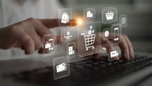 Hand interacting with holographic e-commerce icons on keyboard; research about how consumers decide willingness to pay